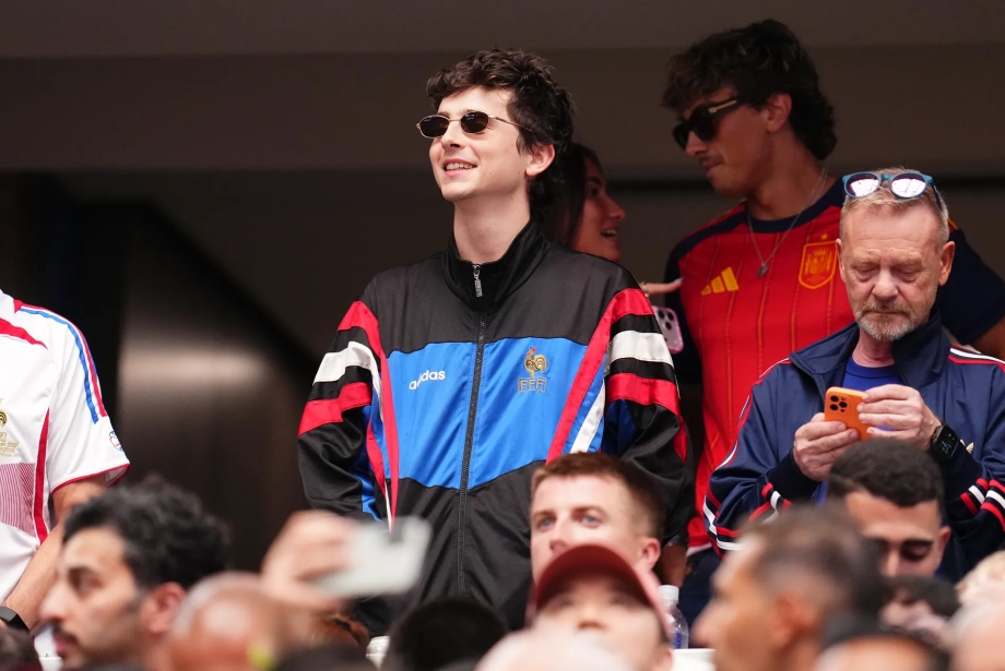 Timothée Chalamet, Fransa-İspanya Dünya Kupası yarı finalini tribünden 1996-98 dönemine ait vintage Adidas Fransa eşofman üstüyle izliyor.