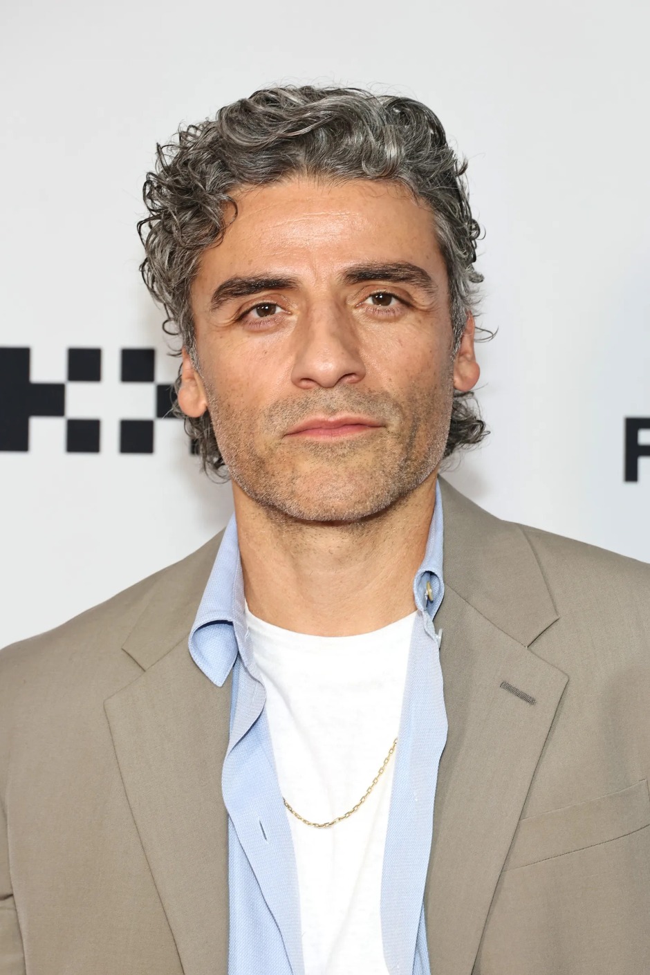 Oscar Isaac'ın dalgalı mini mullet saç modeliyle katıldığı etkinlikten portre.