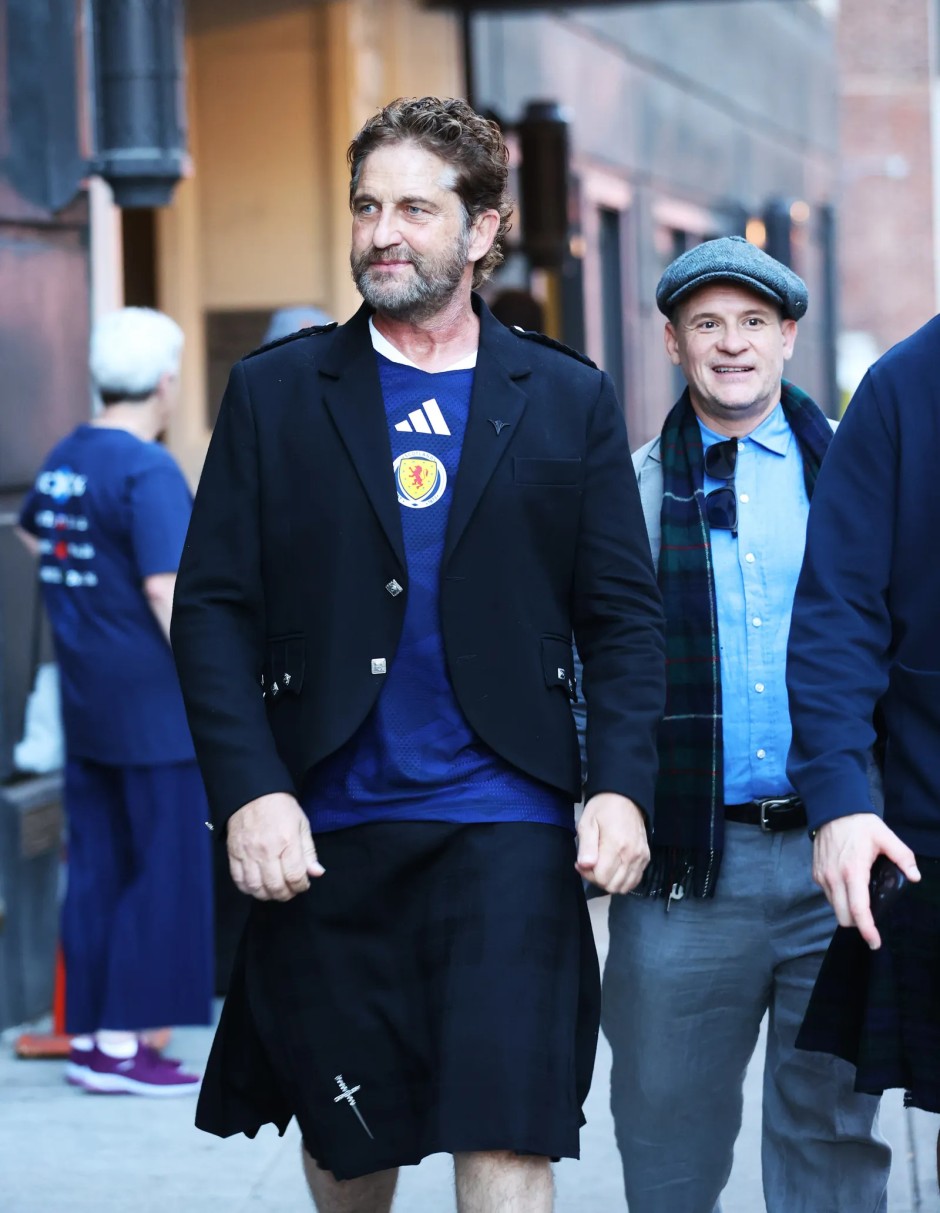 Gerard Butler, İskoçya Milli Takımı formasını siyah blazer ceket ve kilt ile kombinleyerek sokakta yürüyor.
