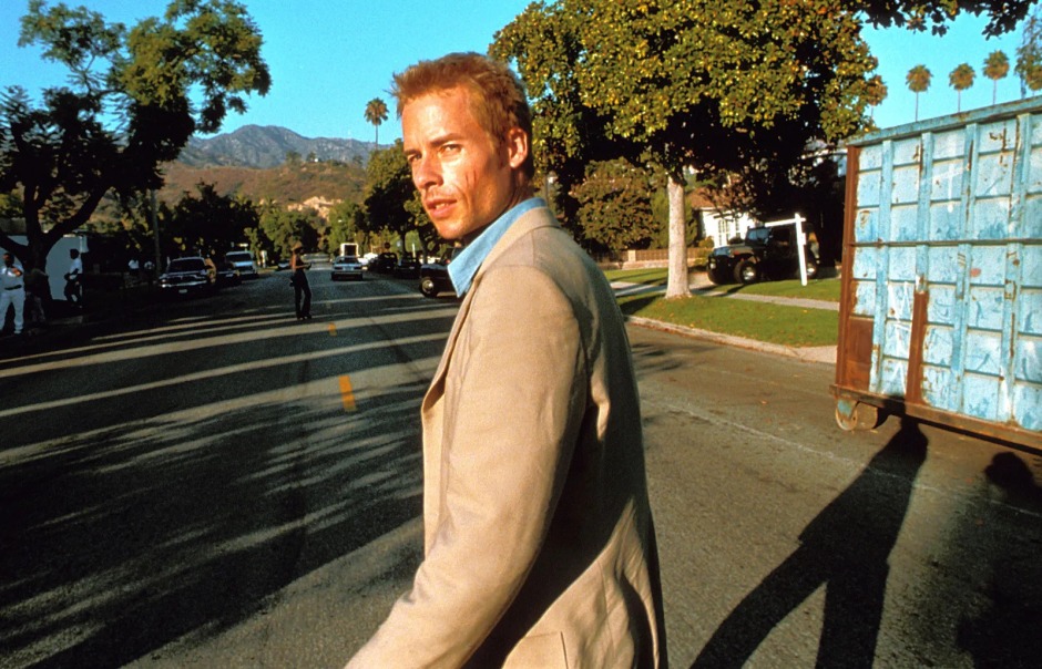 Christopher Nolan'ın Memento (2000) filminden bir sahne; Guy Pearce'in canlandırdığı Leonard Shelby, sakin bir banliyö sokağında arkasına dönüp bakıyor.