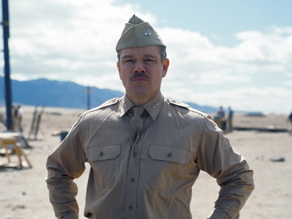 Christopher Nolan'ın Oppenheimer (2023) filminden bir sahne; Matt Damon'ın canlandırdığı General Leslie Groves, Los Alamos'taki test sahasında üniformasıyla ayakta duruyor.